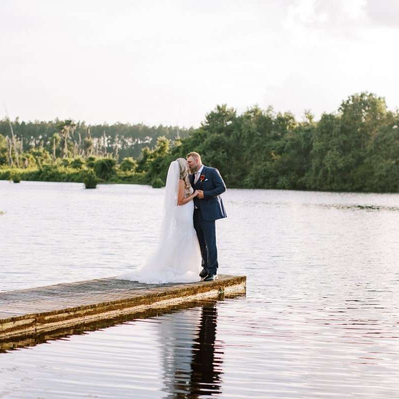bride and groom on a dock by a lake in Jacksonville by Laura Perez Photography